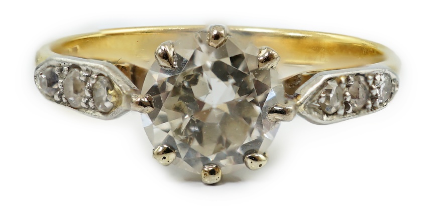 A modern 18ct gold and single stone diamond set ring, with six stone diamond chip set shoulders
